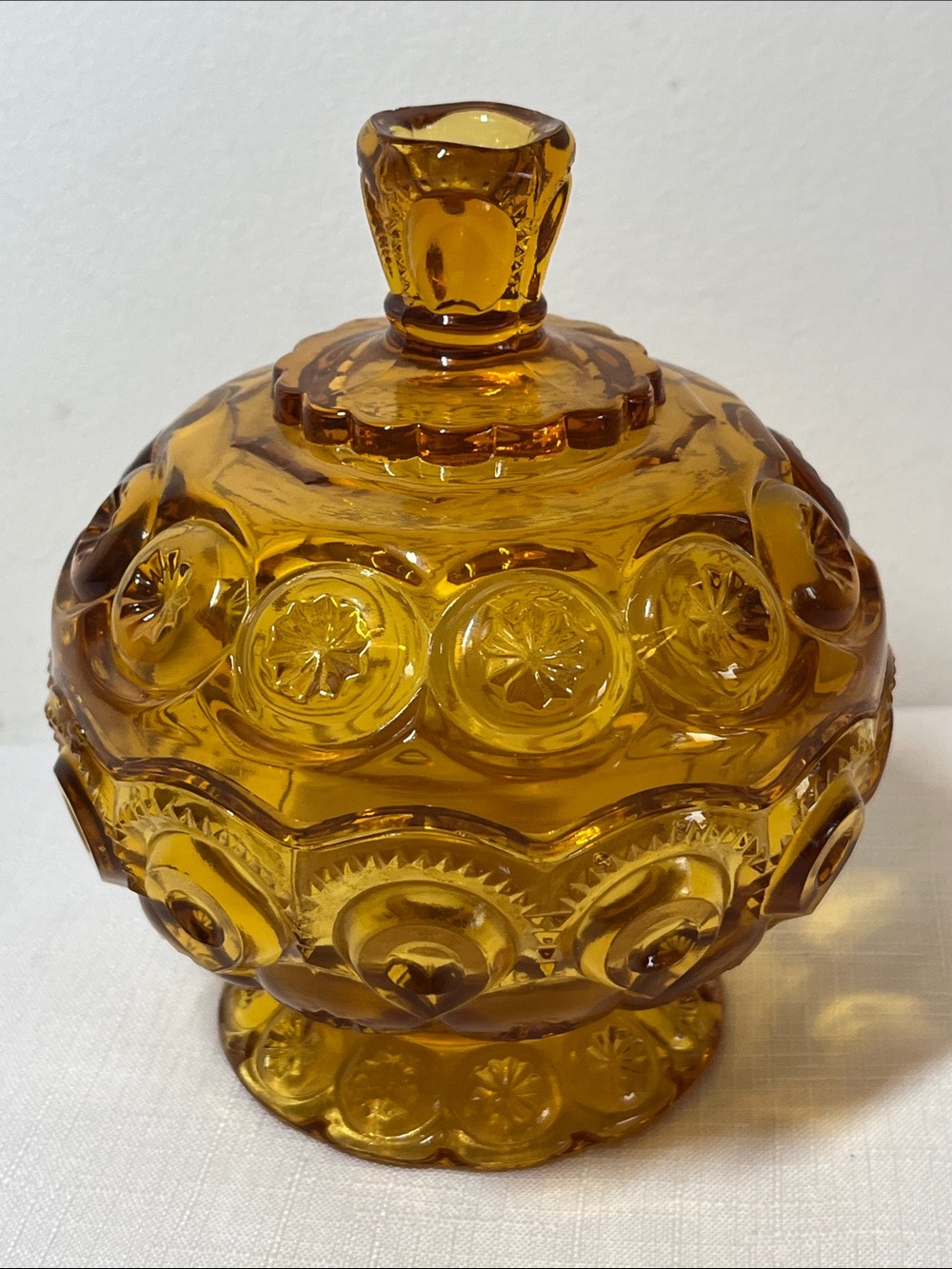 Vintage "Moon and Stars" pattern lidded candy dish in amber glass